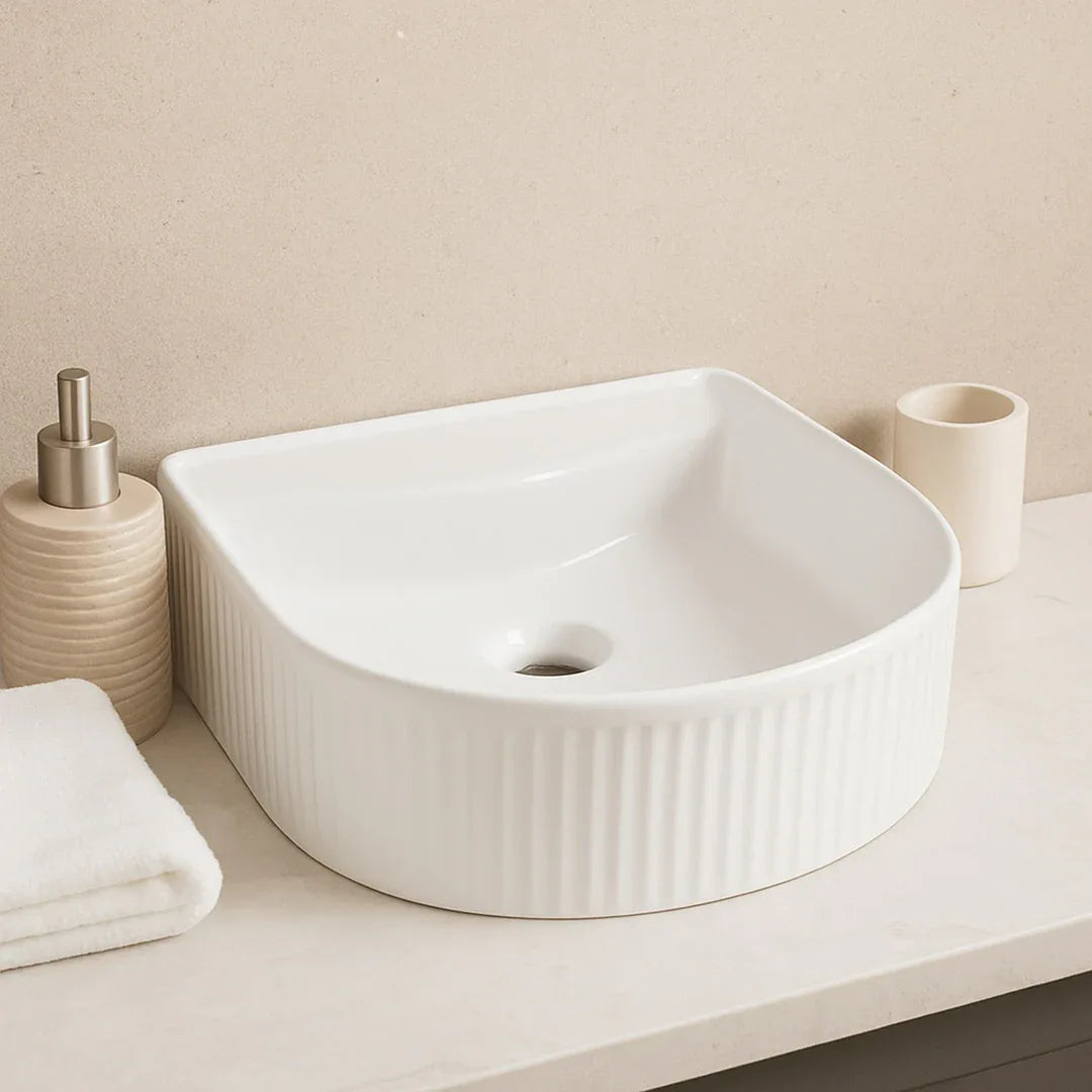 White ceramic sink on a bathroom counter with a beige towel and soap dispenser.