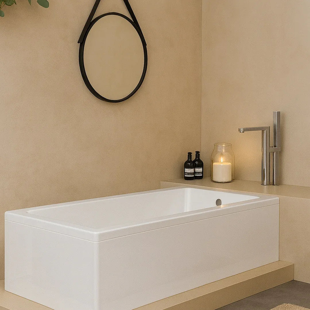 Modern bathroom with a white bathtub, candle, and bottles on a beige countertop.