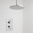 Chrome shower head and control panel on a tiled bathroom wall