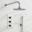 Chrome shower head and control panel on a marble wall
