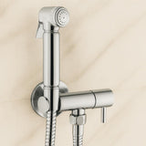Chrome bathroom faucet with handheld shower head on a beige tiled wall background