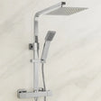 Chrome shower system with rain shower head and handheld shower on a light background