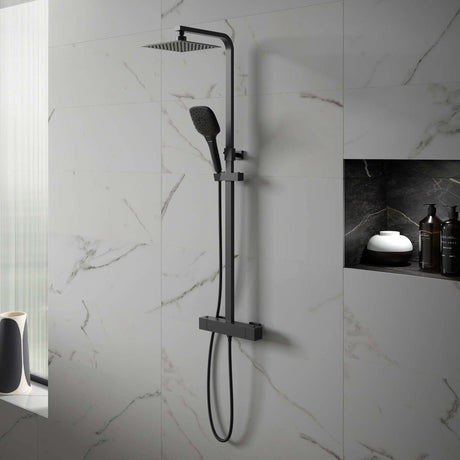 Black shower system mounted on a marble bathroom wall
