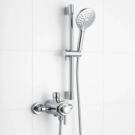 Chrome shower head and control handle set against a white tiled wall.