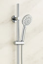 Chrome shower head and hose on a light beige background