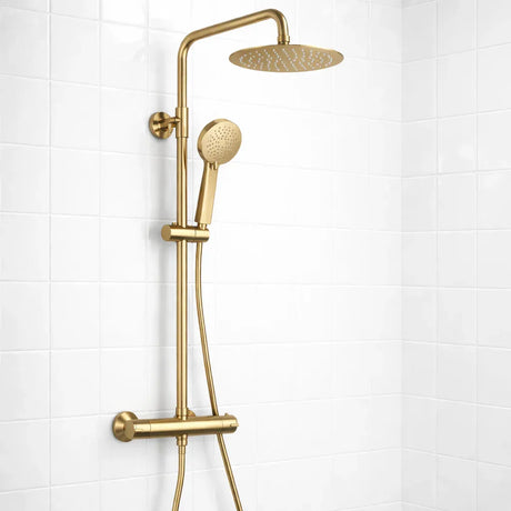 Gold shower set with rain shower head and handheld shower on a white tiled wall.