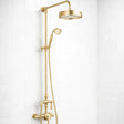 Gold shower set with rain shower head and handheld shower on a white tiled wall.
