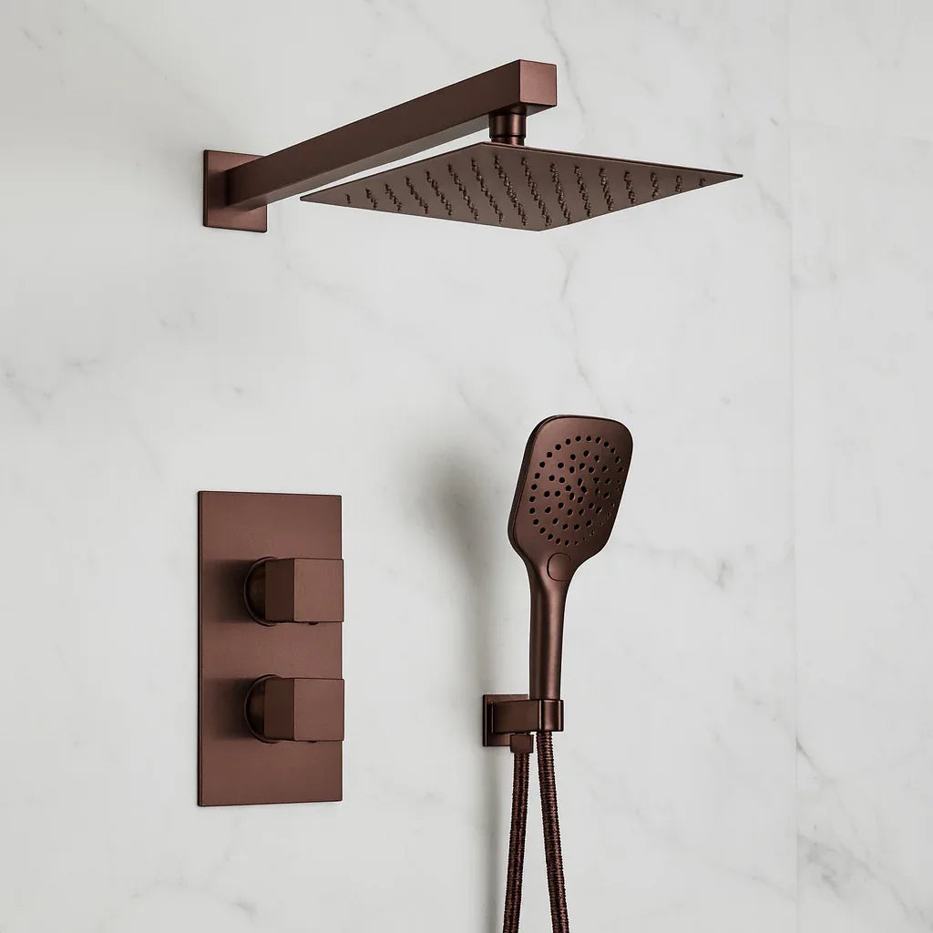 Bronze shower head and control panel on a white marble wall