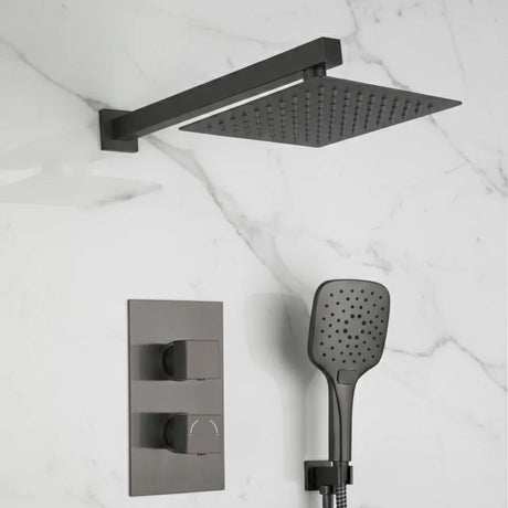 Black shower head, rectangular shower arm, and handheld shower on a marble wall.