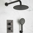 Black shower head, handheld shower, and control panel on a marble background