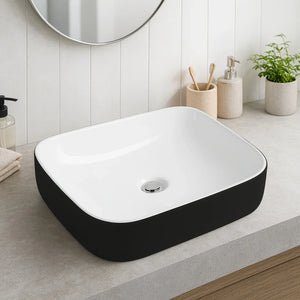Rectangular black and white sink in a modern bathroom setting with a mirror and plants.