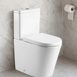 White toilet in a bathroom with gray tiled walls and a roll of toilet paper.