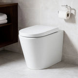 Modern white toilet in a bathroom with tiled walls and a wooden shelf.