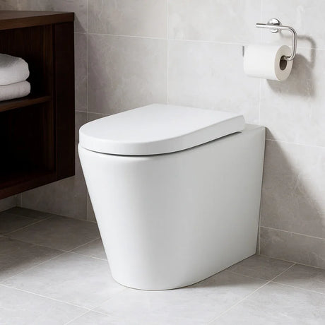 Modern white toilet in a bathroom with tiled walls and a wooden shelf.