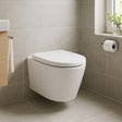 Modern white wall-mounted toilet in a bathroom with tiled walls and a window.