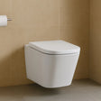 Wall-mounted white toilet against a beige tiled wall