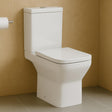 White toilet against a beige tiled wall