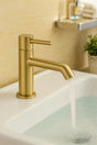 Gold faucet on a sink with a blurred bathroom background