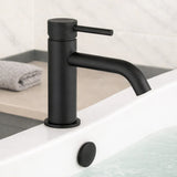 Black faucet on a bathroom sink with a towel in the background