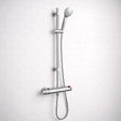 Chrome shower head and hose on a white tiled wall