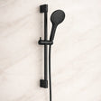 Black shower head with handheld shower on a light beige background