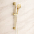 Gold shower head and handheld shower on a beige background
