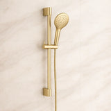 Gold shower head and handheld shower on a beige background