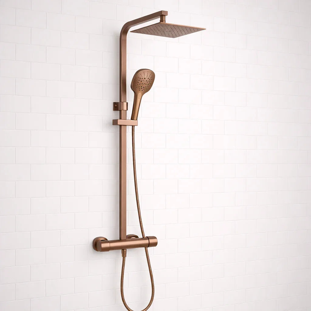 Rose gold shower system with rain shower head and handheld shower on a white tiled wall background