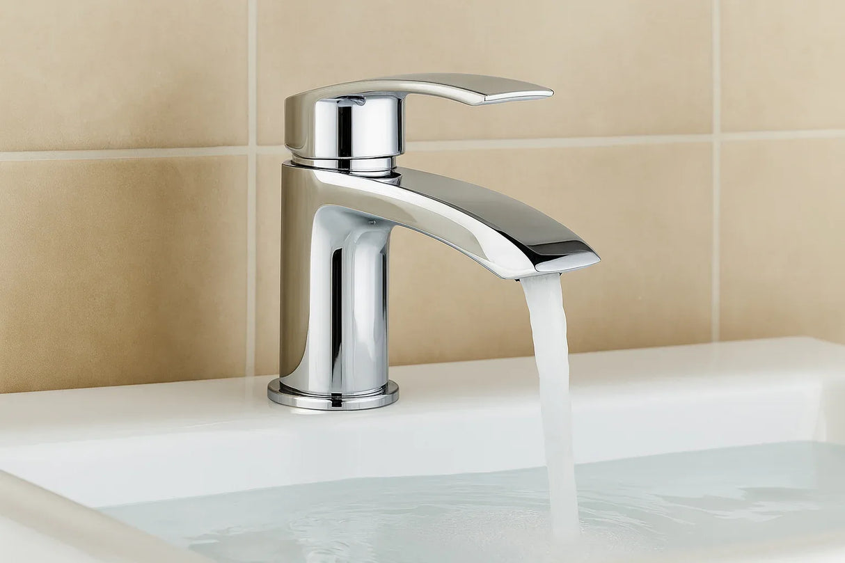 Chrome faucet with running water on a beige tiled wall background