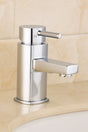 Chrome bathroom faucet on a beige tiled wall