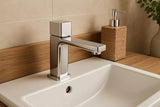 Chrome faucet on a sink with a textured soap dispenser in the background.