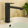 Black faucet on a bathroom sink with a blurred background