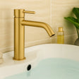 Gold faucet on a sink with a neutral background