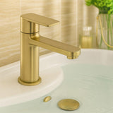 Gold faucet on a sink with a blurred background