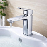 Chrome faucet on a white sink with water flowing, against a neutral background.