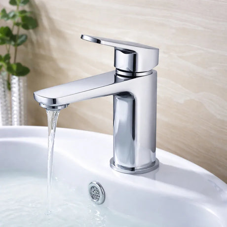 Chrome faucet on a white sink with water flowing, against a neutral background.