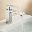 Chrome faucet with water flowing into a sink against a beige background