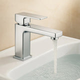 Chrome faucet with water flowing into a sink against a beige background