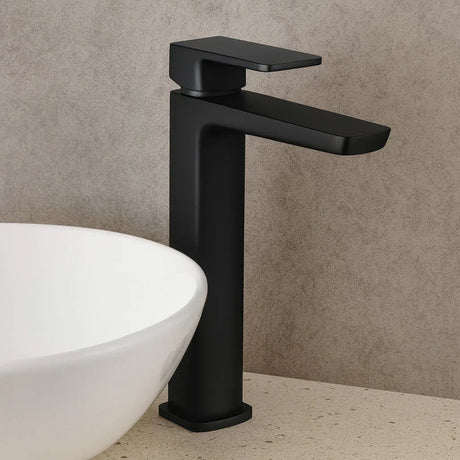 Black faucet mounted on a beige wall with a white sink.