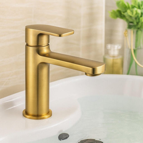 Gold faucet on a sink with a blurred background